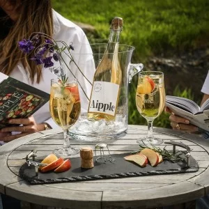 Small slate tray with antler handles on table with wine glasses and bottle